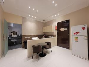 a kitchen with a table and chairs and a refrigerator at لاكازا للشقق الفندقية - La Casa Apartments in Riyadh