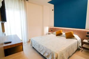 una camera con letto, tavolo e TV di Hotel Taormina a San Benedetto del Tronto