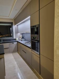 a kitchen with stainless steel appliances and white cabinets at Vue panoramique sur la baie de Tanger in Tangier