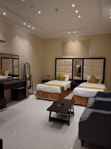 Habitación de hotel con 2 camas y sofá en لاكازا للشقق الفندقية - La Casa Apartments en Riad