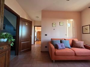 una sala de estar con un sofá naranja con almohadas. en Agriturismo Garzolé, en Castelfranco Emilia