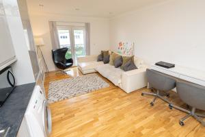 Newly refurbished apartment في Elmers End: غرفة معيشة مع أريكة بيضاء وطاولة