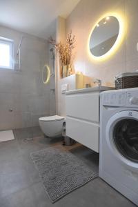 a bathroom with a washing machine and a toilet at Kala House in Zadar