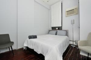 biała sypialnia z białym łóżkiem i krzesłem w obiekcie Beautiful 4BR 1Bath in Chamber Street NYC w Nowym Jorku