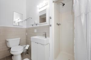 a white bathroom with a toilet and a sink at Beautiful 4BR 1Bath in Chamber Street NYC in New York