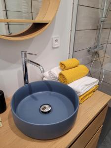 a blue sink in a bathroom with towels on a counter at A L'OMBRE DE LA TREILLE -Proche Saint-Emilion in Saint-Magne-de-Castillon