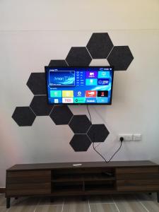 a wall with a tv on a wall at Red Triangle Cottage Roomstay Kerteh Paka in Kampong Pengkalan Pangan +29 photos