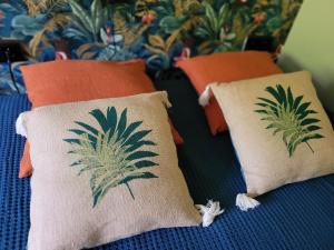 two pillows with palm trees on them on a bed at A L'OMBRE DE LA TREILLE -Proche Saint-Emilion in Saint-Magne-de-Castillon