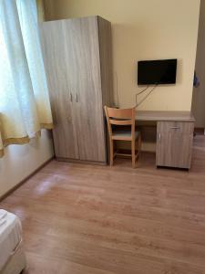a room with a desk with a tv and a chair at Комплекс за гости Малки Воден in Malki Voden