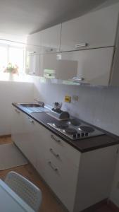 uma cozinha branca com um lavatório e um fogão em Rifugio piemontese em Barge