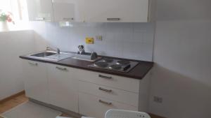 uma pequena cozinha com um lavatório e um fogão em Rifugio piemontese em Barge