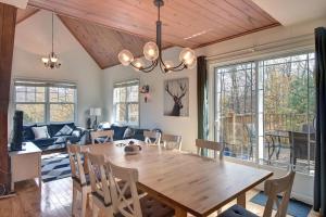 - une salle à manger avec une table et des chaises en bois dans l'établissement The Golf & Mountain View Retreat by Instant Suites, à Mont-Tremblant