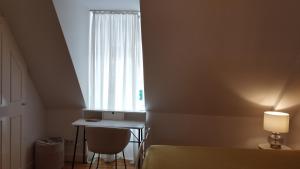 een slaapkamer met een bed, een bureau en een raam bij Stadthaus Zimmer 6 neben dem REM-Museum in Mannheim Mitte in Mannheim