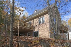 een groot huis met een terras aan de zijkant bij The Golf & Mountain View Retreat by Instant Suites in Mont-Tremblant