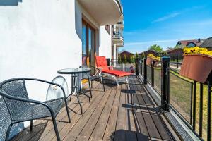 una terraza de madera con sillas y mesa en Pod Jedynkami, en Władysławowo