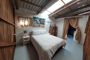 1 dormitorio con 1 cama en una habitación con ventana en 11 Mountain Stream Hot Tub Self Catering, en Gordonʼs Bay