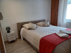 Un dormitorio con una cama grande con almohadas. en Appartement 6 pers, LA VANOISE, GARAGE motos vélos, en Fourneaux