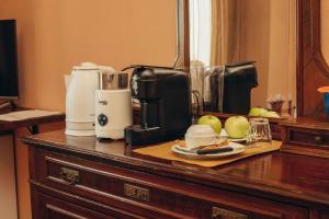 a counter top with a coffee maker and apples on it at Agriturismo Garzolé in Castelfranco Emilia