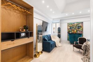 a living room with a blue couch and a painting at CIRCLE PIAZZA DI SPAGNA 60 SUITES COLLECTION in Rome