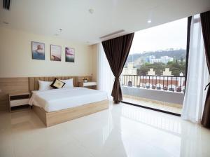 a bedroom with a bed and a large window at Lucasta Hotel Ha Long in Ha Long +82 photos