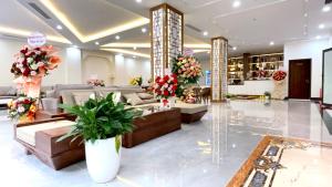 eine Lobby mit Sofas und Blumen in einem Laden in der Unterkunft Lucasta Hotel Ha Long in Hạ Long