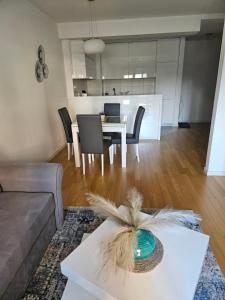 ein Wohnzimmer mit einem Sofa und einem Tisch mit Stühlen in der Unterkunft Stylish New Belgrade apt parking 5e per day in Belgrad