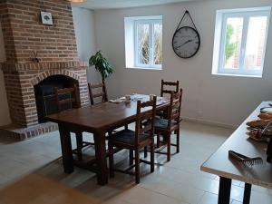 a dining room with a table and a fireplace at A l'Ombre des Bois, Chambre double vue jardin in Neung-sur-Beuvron