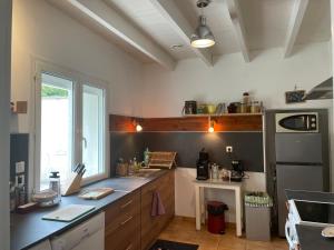 a kitchen with a counter and a sink and a refrigerator at La maison d’Eloi in Montignac-Charente
