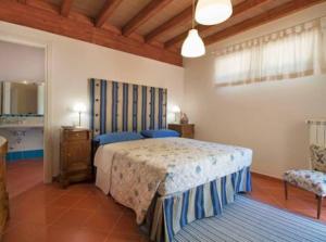 a bedroom with a bed and a chair in it at Incantevole villa full optional all'Isola d'Elba in Marina di Campo
