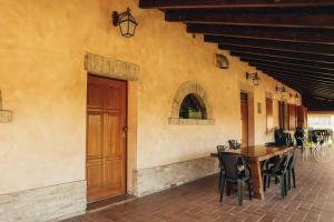 un patio con mesa de madera y sillas junto a un edificio en Agriturismo Garzolé, en Castelfranco Emilia