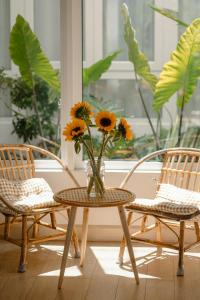 a vase of flowers sitting on a table with two chairs at La Maison in Ấp Tân An (2)