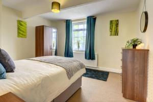 a bedroom with a large bed and a window at 6 bedrooms, sleeps up to 16, secure parking space & comfort in Skegby