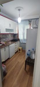 een keuken met een witte koelkast en een houten vloer bij 2+1 flat fully furnished for renting. in Çiftlikköy