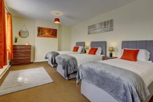 a bedroom with two beds and a dresser at 6 bedrooms, sleeps up to 16, secure parking space & comfort in Skegby