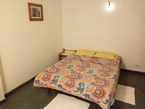 a bedroom with a bed with a colorful blanket at Location lydie in Antananarivo