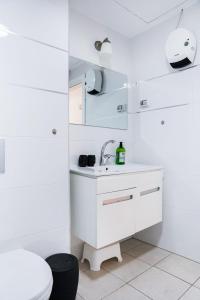 a white bathroom with a sink and a toilet at View of Paradise in Bat Yam