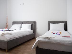 dos camas sentadas una al lado de la otra en una habitación en Hotel Rezime, en Zenica