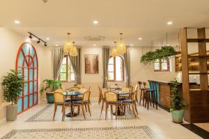a dining room with tables and chairs and windows at Palo Santo Hotel Phu Quoc in Phú Quốc