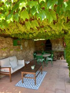 une terrasse avec une table et des chaises sous un grand arbre verdoyant dans l'établissement Els Masos de Caula, à Gérone