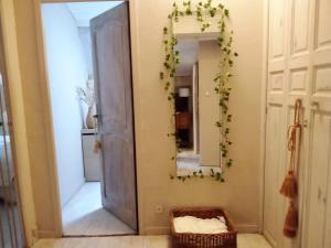 a hallway with a mirror and a wreath on the wall at La maison perchee in Aigues-Mortes