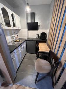 een kleine keuken met een houten tafel en een stoel bij Apartman Didi2- free private parking-garage in Novi Sad