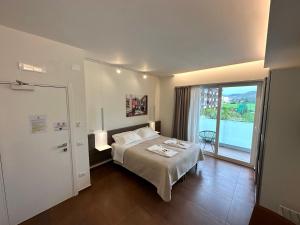 a hotel room with a bed and a large window at Eich Business Accommodation in Santa Maria Capua Vetere