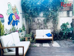 un patio con 2 sillas blancas y una almohada azul en Rent Campana en Buenos Aires