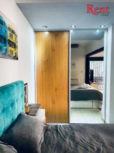 1 dormitorio con cama y espejo grande en Rent Campana en Buenos Aires
