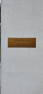 una señal en el costado de una pared blanca en Apartman Naza en Kulen Vakuf