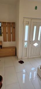 a room with a door and a white tile floor at Apartman Naza in Kulen Vakuf
