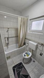 a bathroom with a toilet and a bath tub at Apartman Naza in Kulen Vakuf