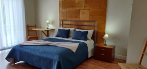 a bedroom with a large bed with blue sheets at Rainbow Guest House in Madalena