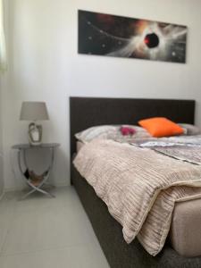 a bedroom with a bed and a table with a picture at Apartmán Lodenica in Piešťany