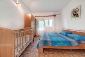 a bedroom with a bed and a crib at Pristan Apartments in Dodoši +20 photos